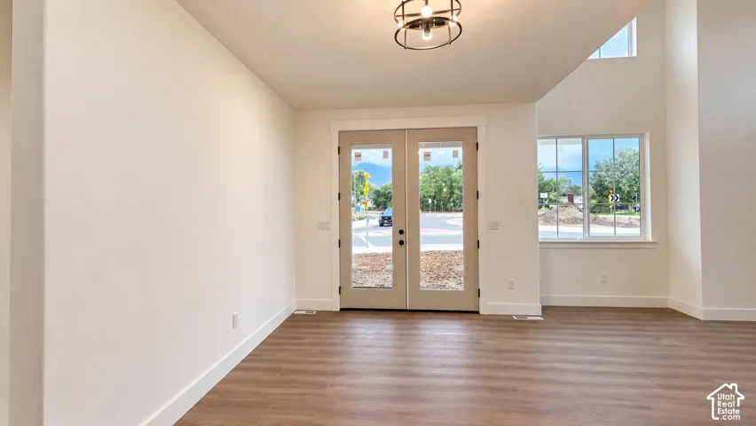 Double French door entryway featuring wood-finish flooring, a multi-light spherical chandelier, and expansive windows