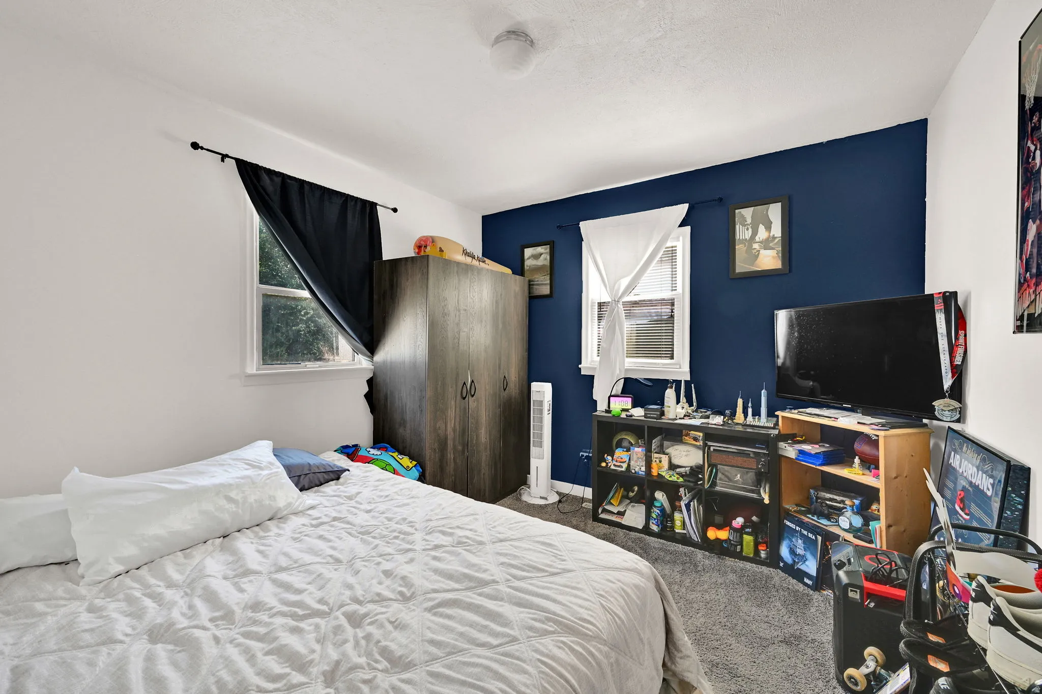 Bedroom featuring two windows, a ceiling light fixture, and a mix of white and blue painted walls