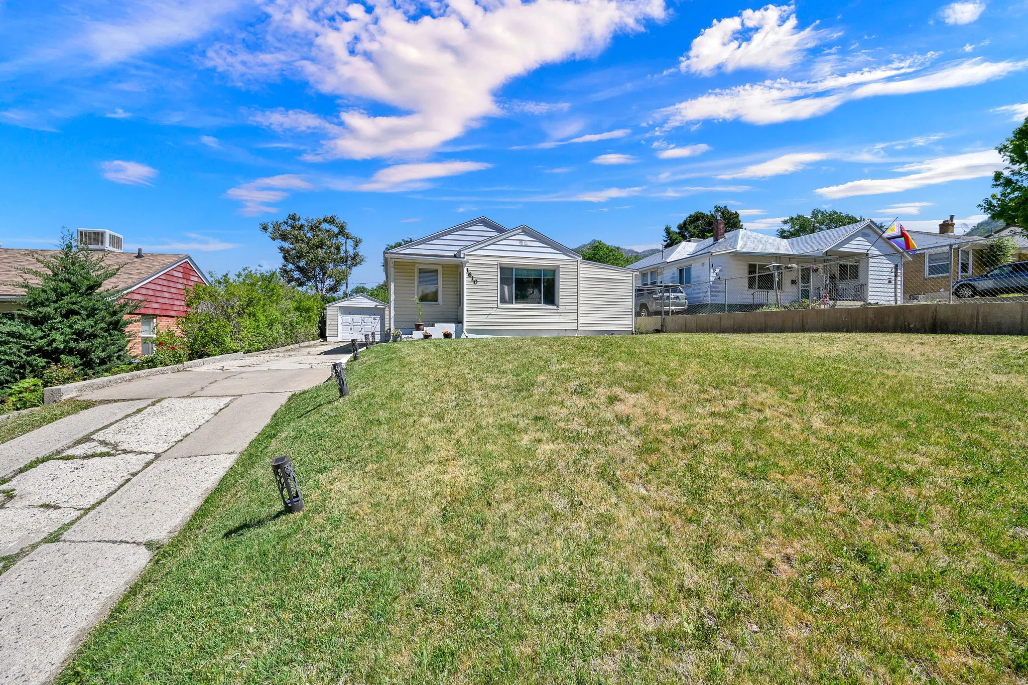 Single-story residence featuring a front lawn and a concrete driveway
