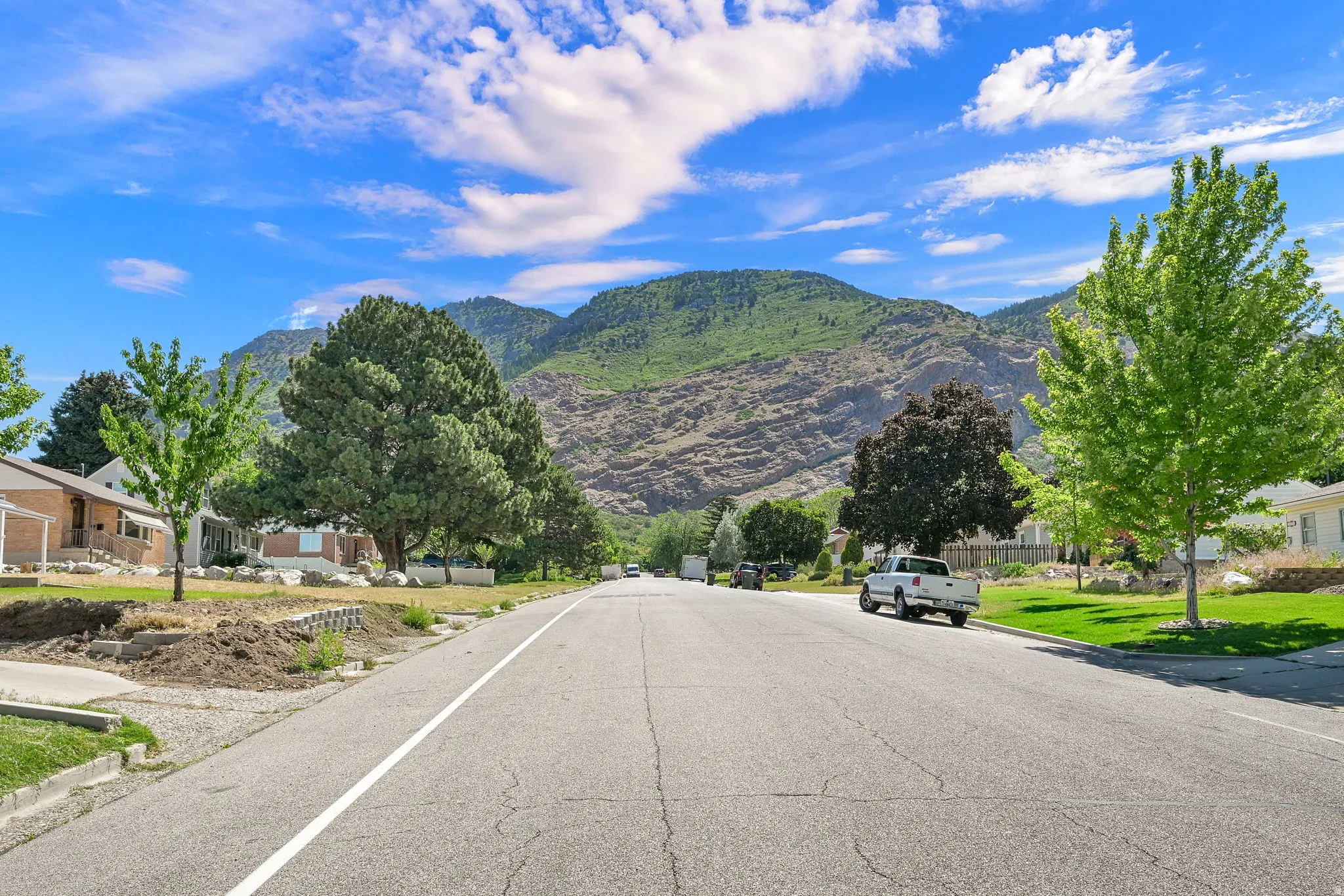 Mountainous backdrop with established neighborhood featuring mature trees and street-level homes