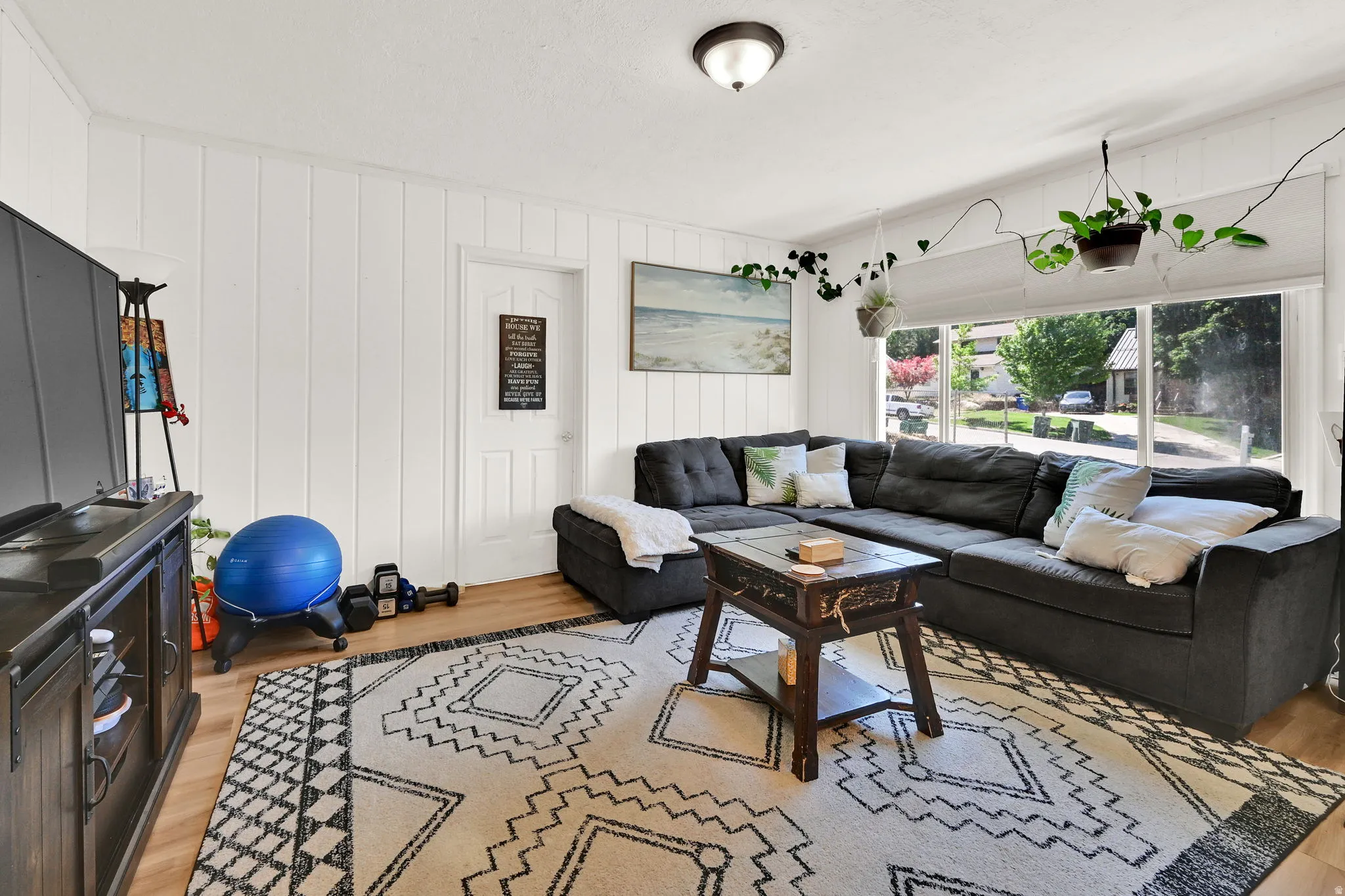 Bright interior space featuring white vertical paneling and wood-finish flooring