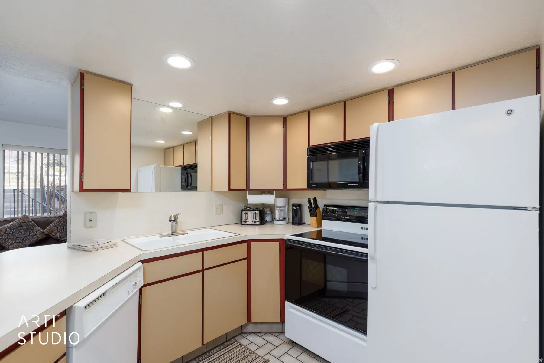 Kitchen featuring white appliances, recessed lighting, ample cabinetry, a built-in microwave, and a white sink