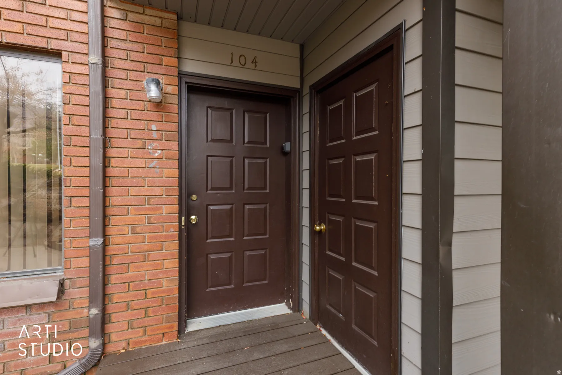 Exterior entrance featuring brick and siding finishes