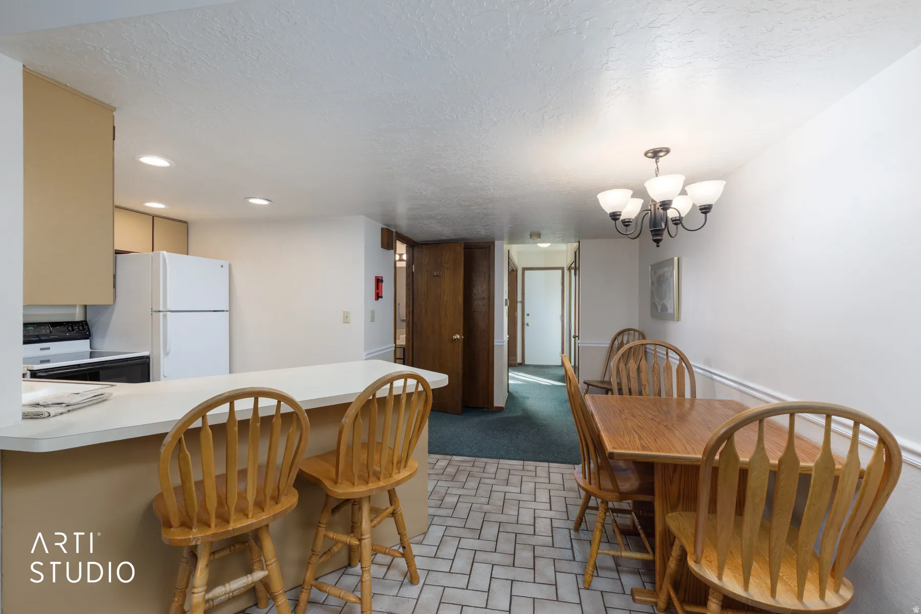 Kitchen and dining area featuring a breakfast bar with counter seating, neutral cabinetry, and recessed lighting