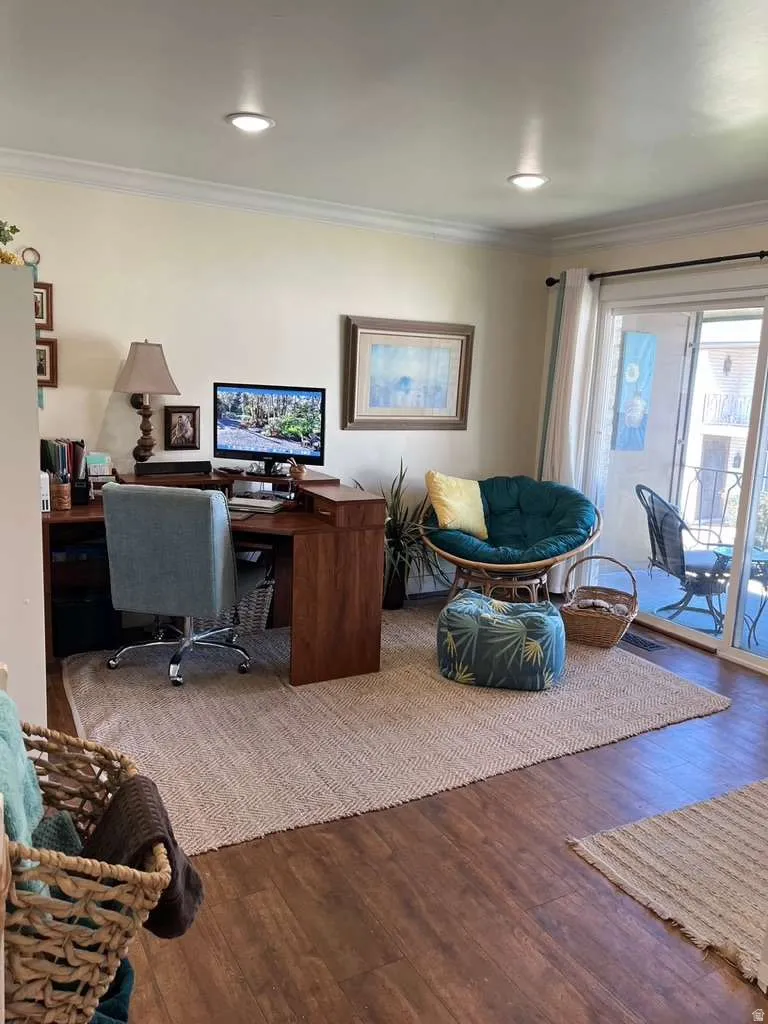 Spacious room featuring wood-finish flooring, recessed lighting, and crown molding