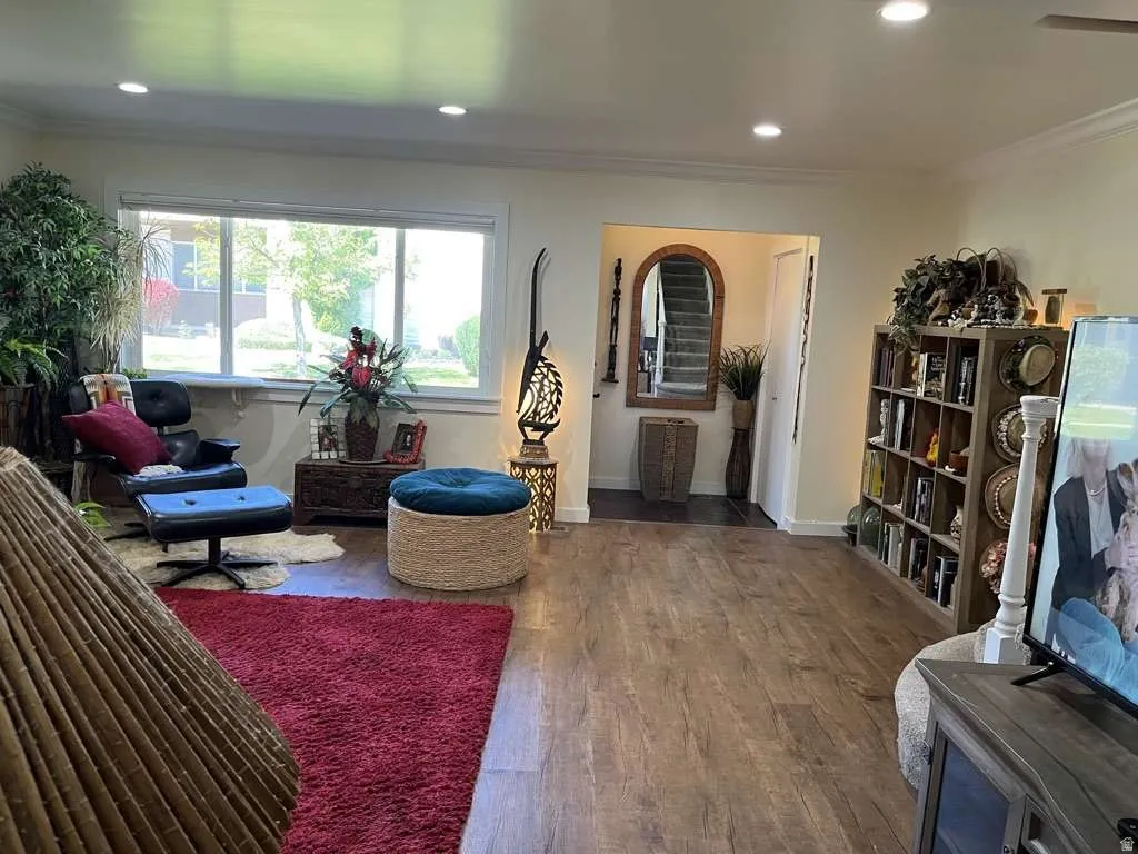 Spacious interior featuring wood-finish flooring, recessed ceiling lighting, and crown molding