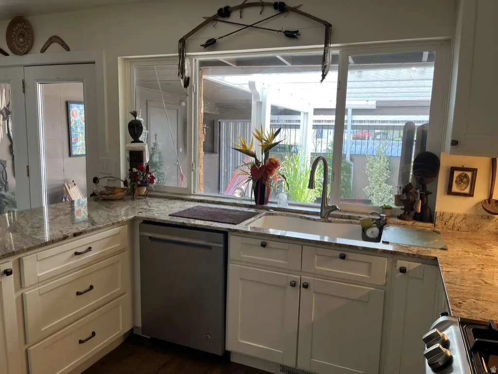 Kitchen workspace featuring granite countertops, white shaker-style cabinetry, stainless steel dishwasher, a single-basin sink with gooseneck faucet, and a large window