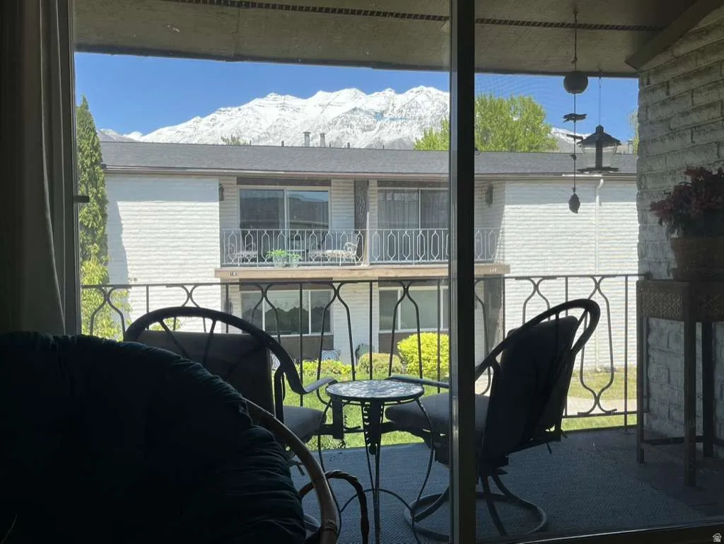 Private balcony featuring a black metal railing and a partial mountain backdrop