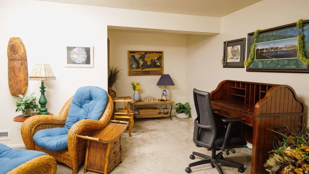 Recessed wall niche, built-in desk with cubbies, light beige carpeting, white painted walls, and an open doorway