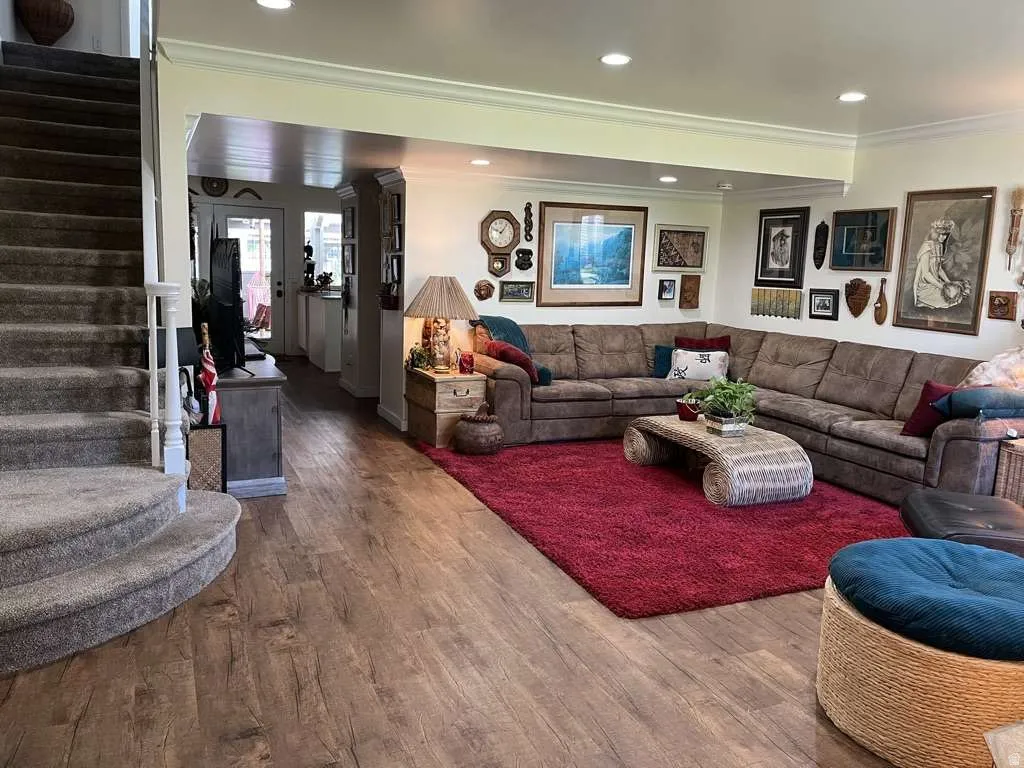 Spacious living area featuring wood-finish flooring and recessed lighting