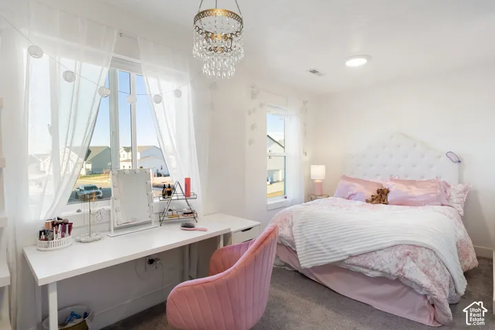 Spacious room featuring a large window, recessed ceiling light, and a prominent tufted headboard