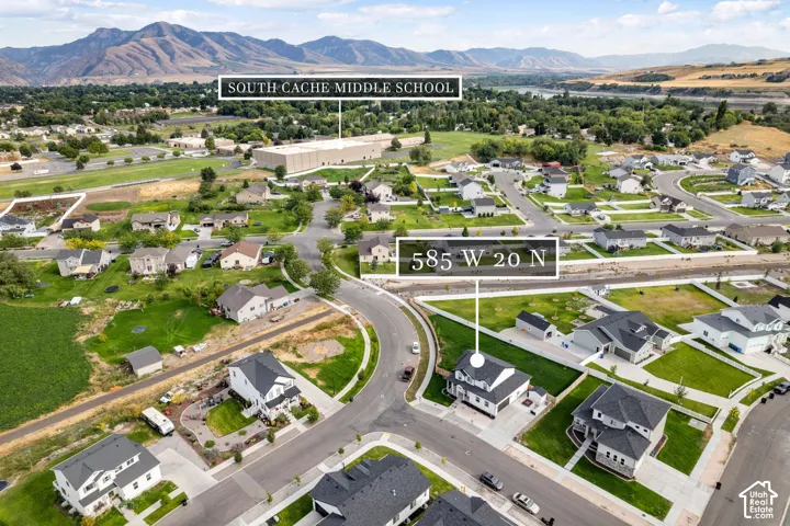 Aerial perspective showcasing a residential neighborhood with mountain backdrops and a visible body of water