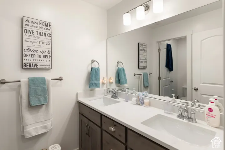 Dual vanity with undermount sinks, chrome faucets, and white countertops