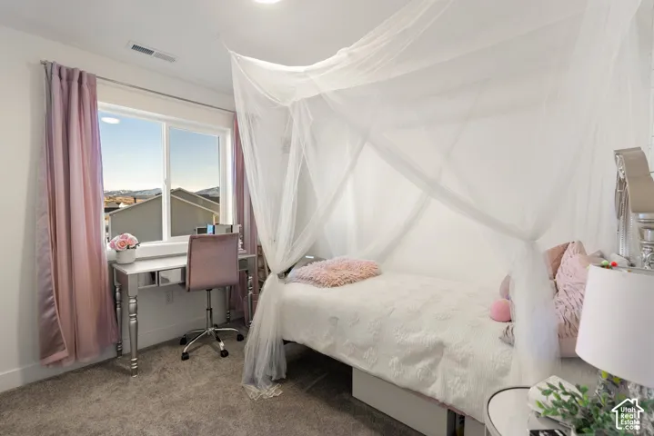 Carpeted room featuring a large window, recessed lighting, and a built-in air vent