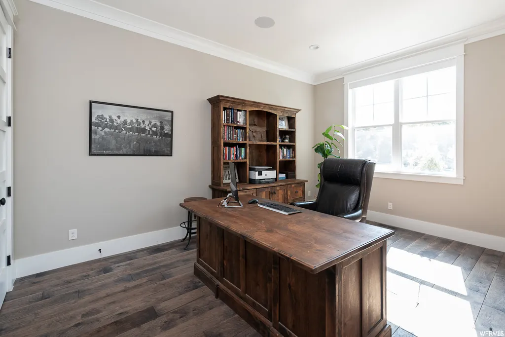 Wood-finish flooring throughout, featuring crown molding, a built-in ceiling speaker, and a large multi-pane window