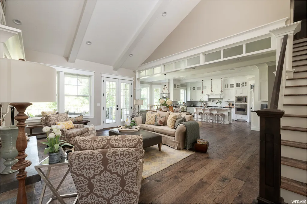 Vaulted living room with exposed ceiling beams and wood-finish flooring