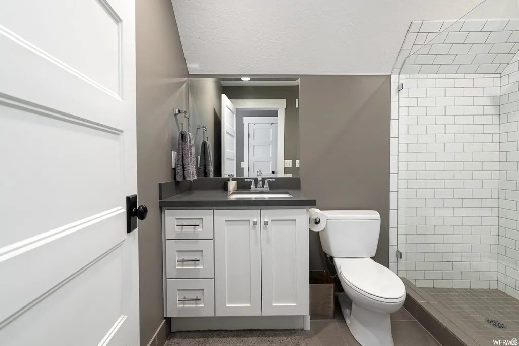 Bathroom featuring a white subway tile shower with a glass enclosure