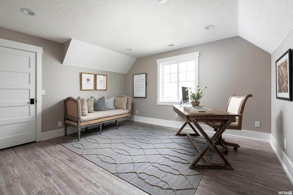 Spacious room featuring wood-finish flooring, neutral wall paint, and white trim
