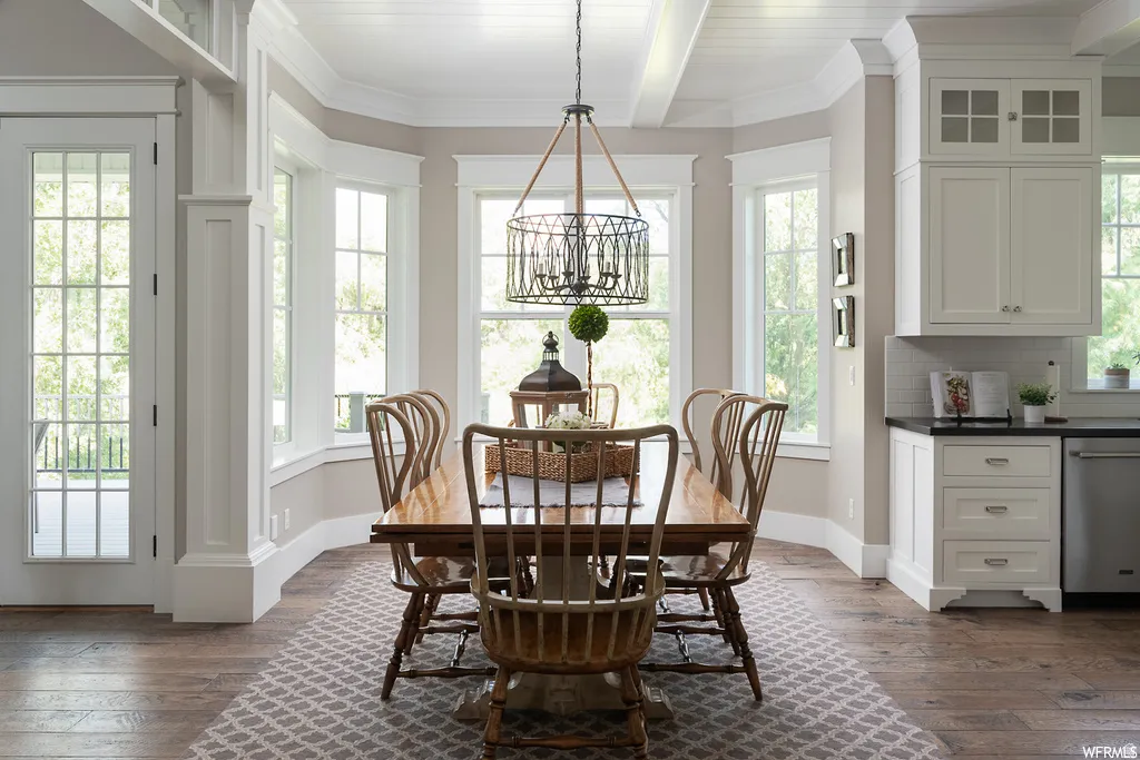 Dining area featuring a wood-finish table, a decorative chandelier, and abundant natural light from multiple windows