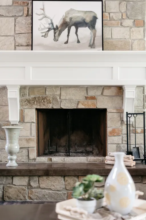 Stone-clad fireplace featuring a dark hearth, built-in firebox, and a crisp white mantel
