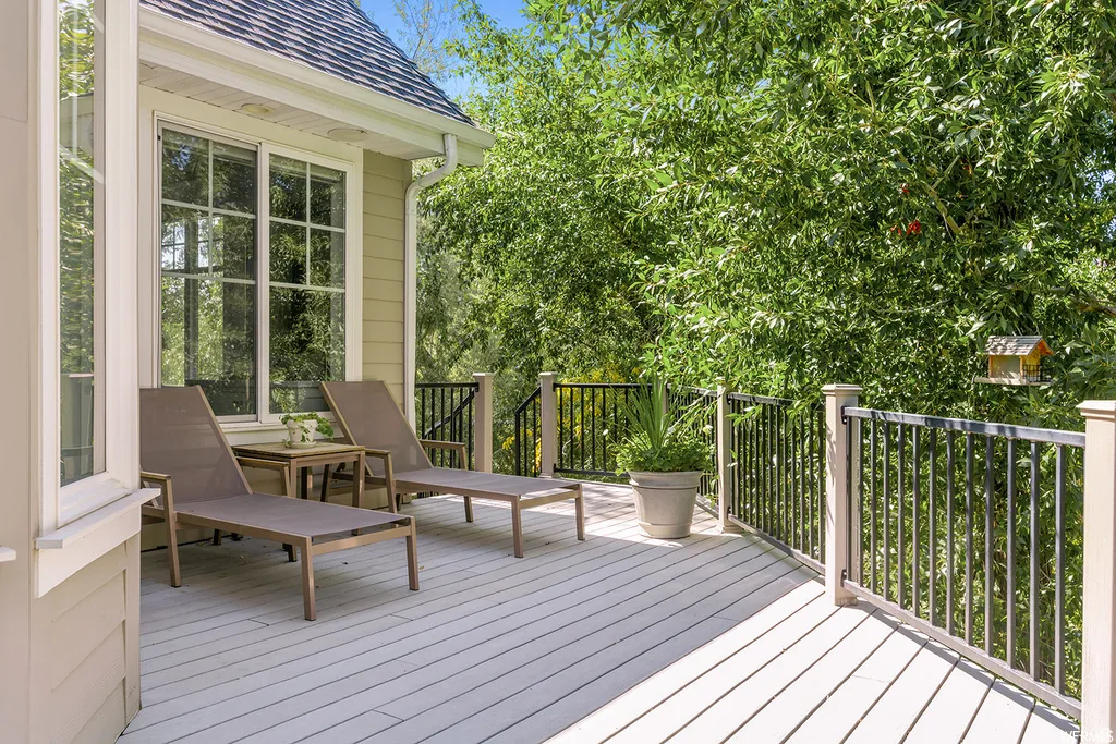 Deck with composite decking, black metal railings, and a detailed window with multiple panes