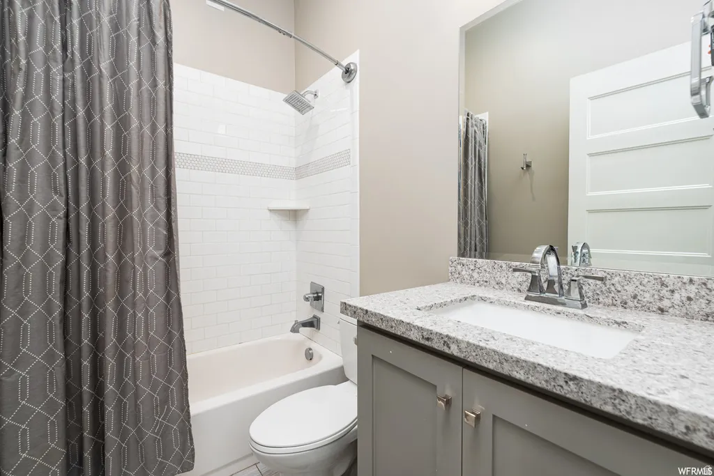 Bathroom vanity with a light-toned speckled countertop and undermount sink