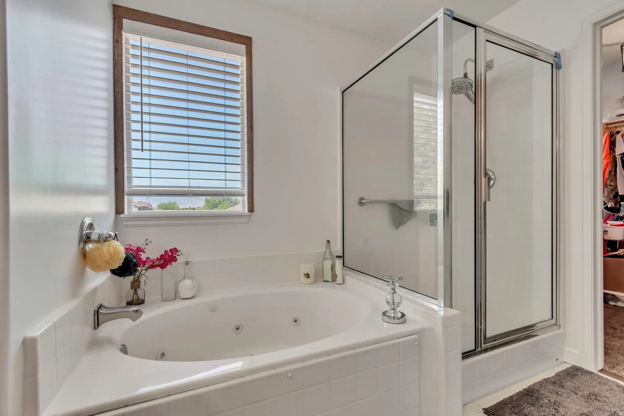 White tile surround soaking tub with integrated jets and chrome fixtures