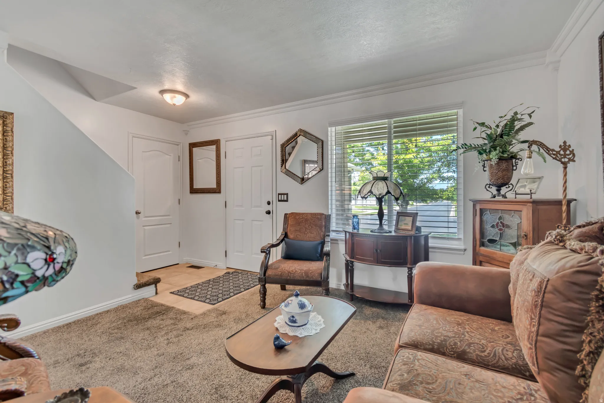 Living area featuring neutral-toned carpeting and white crown molding