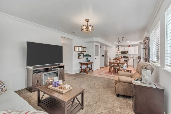 Open concept living area with carpet flooring, crown molding, and recessed lighting