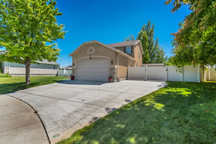 Two-story residence featuring a two-car garage, stone accents, and a concrete driveway