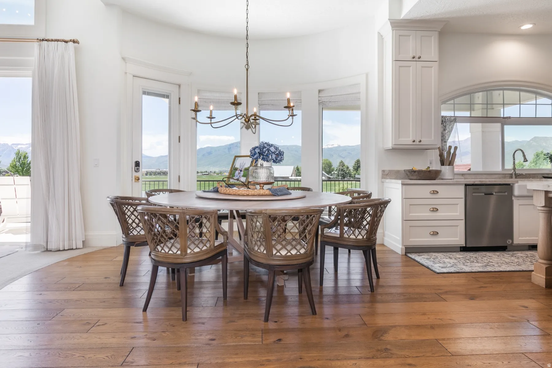 Dining area featuring wood-finish flooring, a spherical chandelier, and expansive windows providing abundant natural light