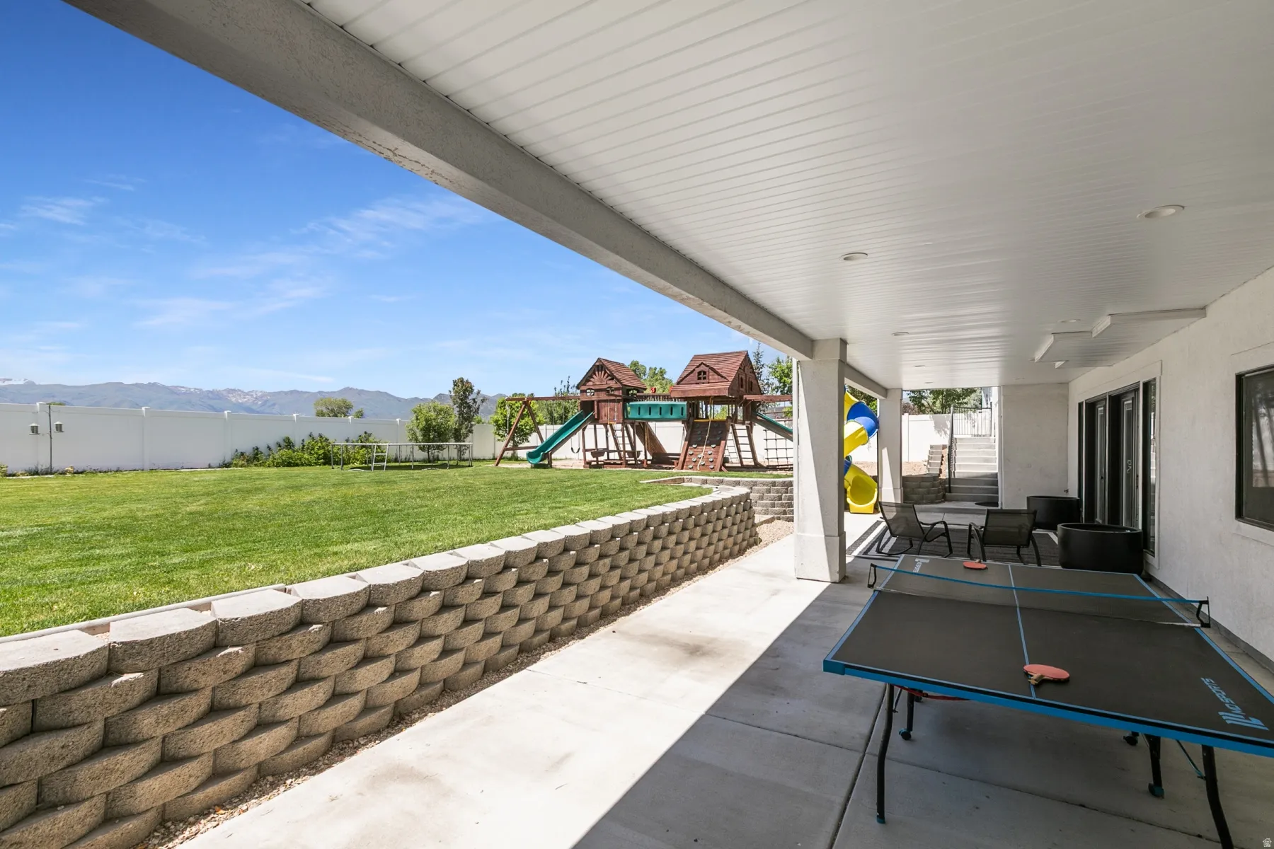 Covered patio with recessed lighting, concrete flooring, and a white privacy fence