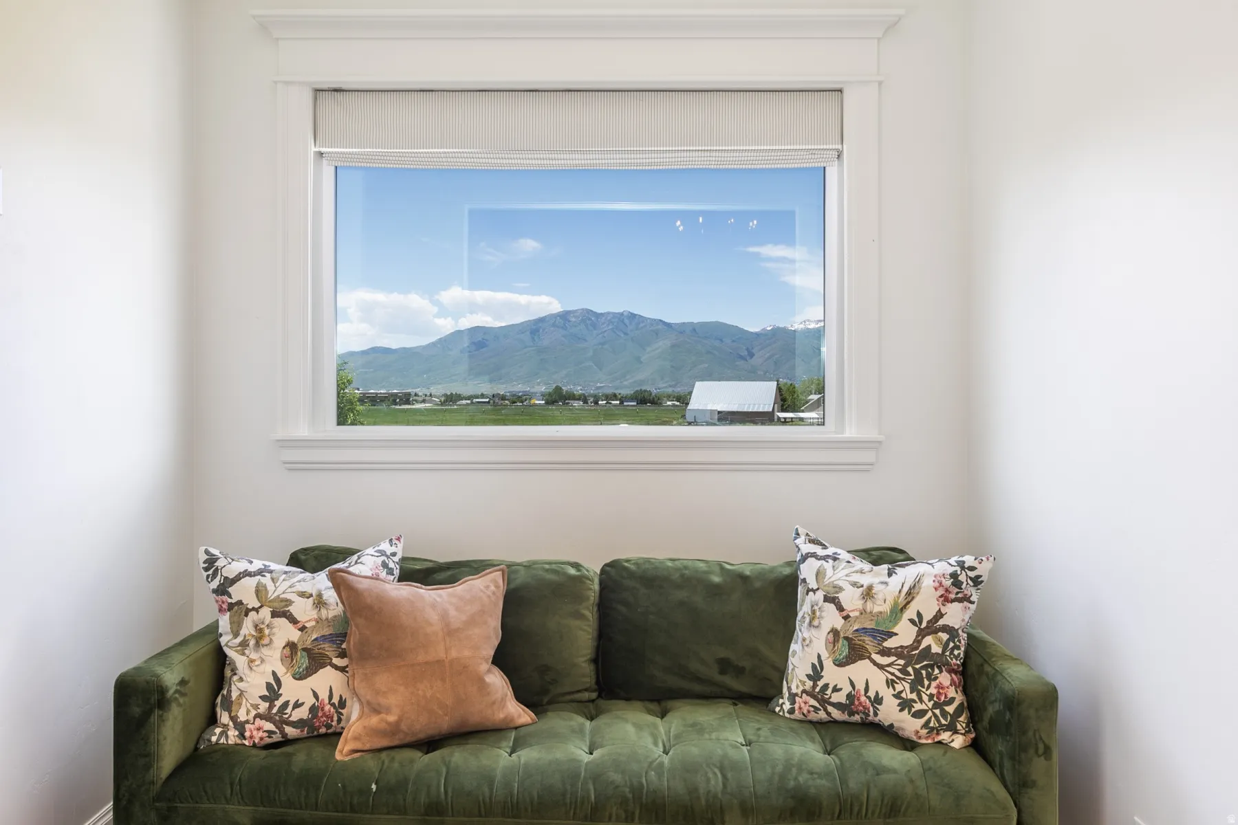 Expansive window with mountain and rural scenery