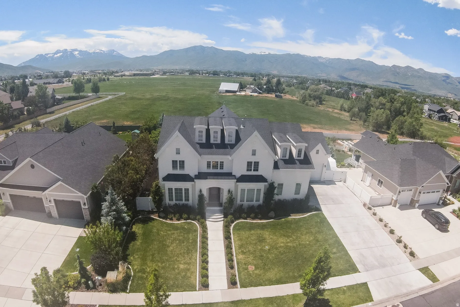 Stately two-story residence featuring a striking white exterior with dark trim accents