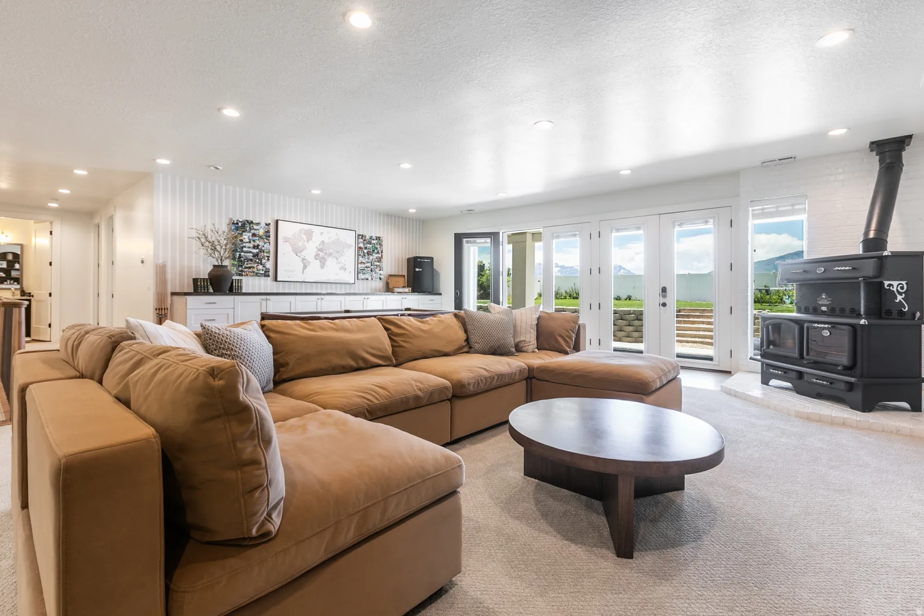 Spacious recreation area featuring a built-in wood-burning stove with white brick surround, multiple French doors, and a built-in media console with white cabinetry