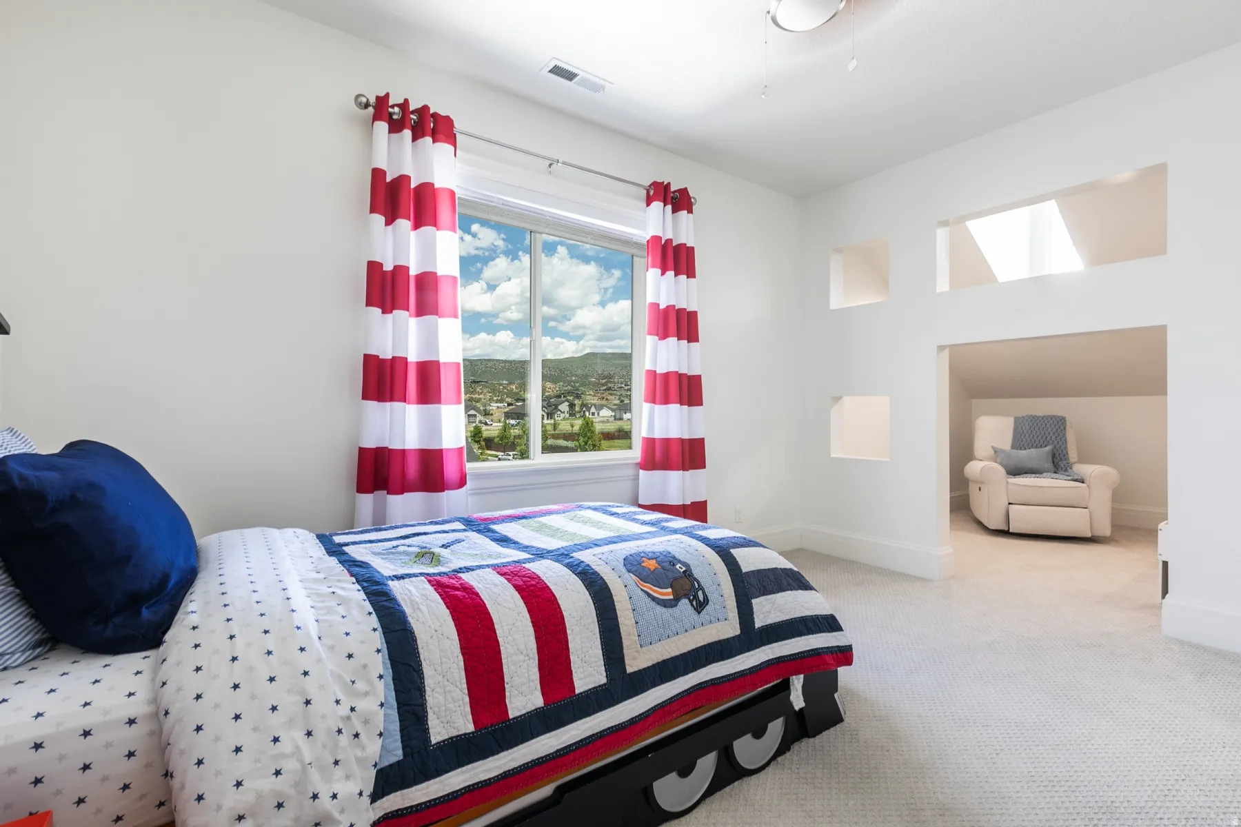 Bedroom featuring a large window, built-in architectural shelving, and a dedicated alcove