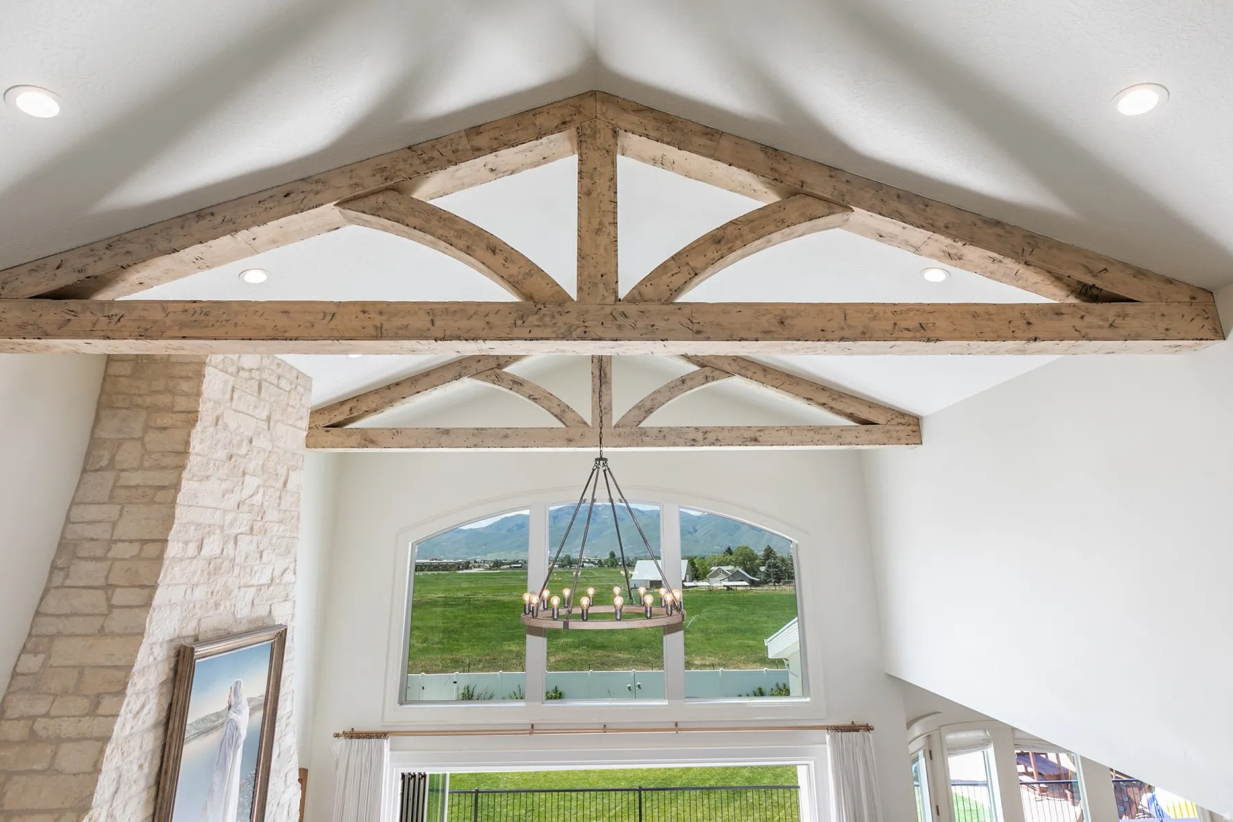 Soaring vaulted ceiling with exposed wood beams and recessed lighting