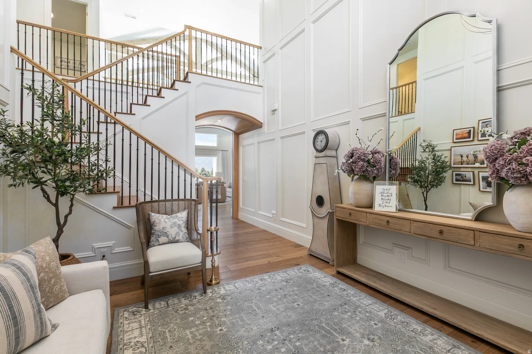 Grand foyer featuring a sweeping staircase with dark metal balusters and wood-finish handrails