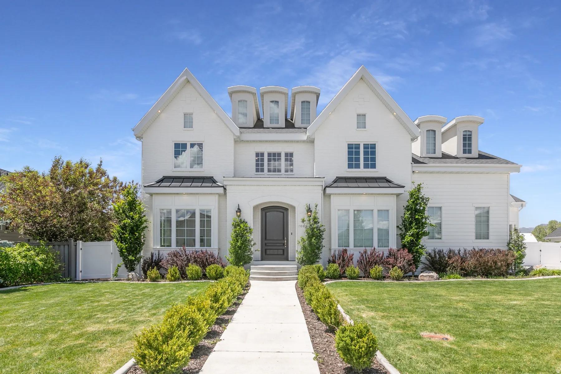White brick exterior with prominent gables and dormer windows