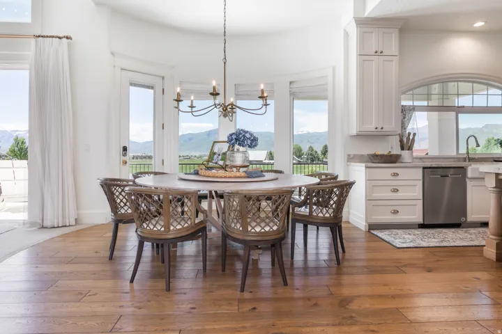 Dining area featuring wood-finish flooring, a spherical chandelier, and expansive windows providing abundant natural light
