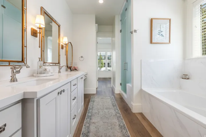 Double vanity featuring white cabinetry and light countertops