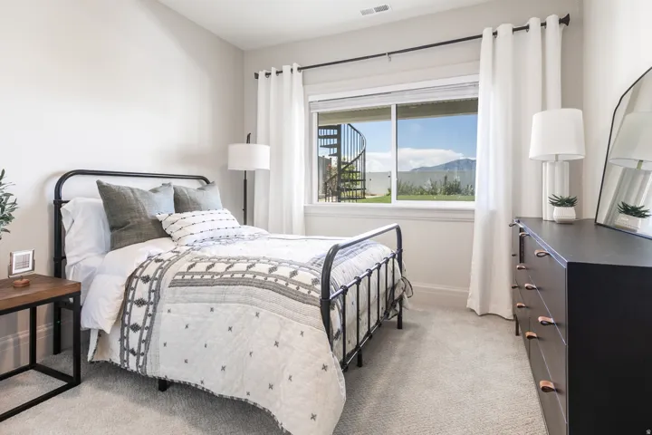 Bright bedroom with light-toned walls and plush carpeting
