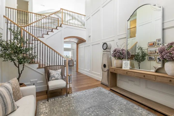 Grand foyer featuring a sweeping staircase with dark metal balusters and wood-finish handrails