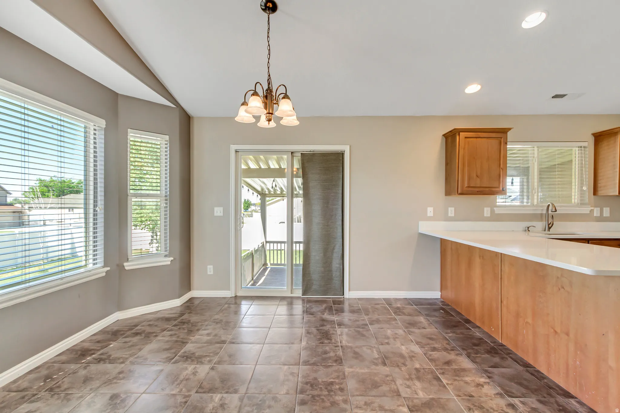 Spacious kitchen and dining area with tile flooring and a patio door