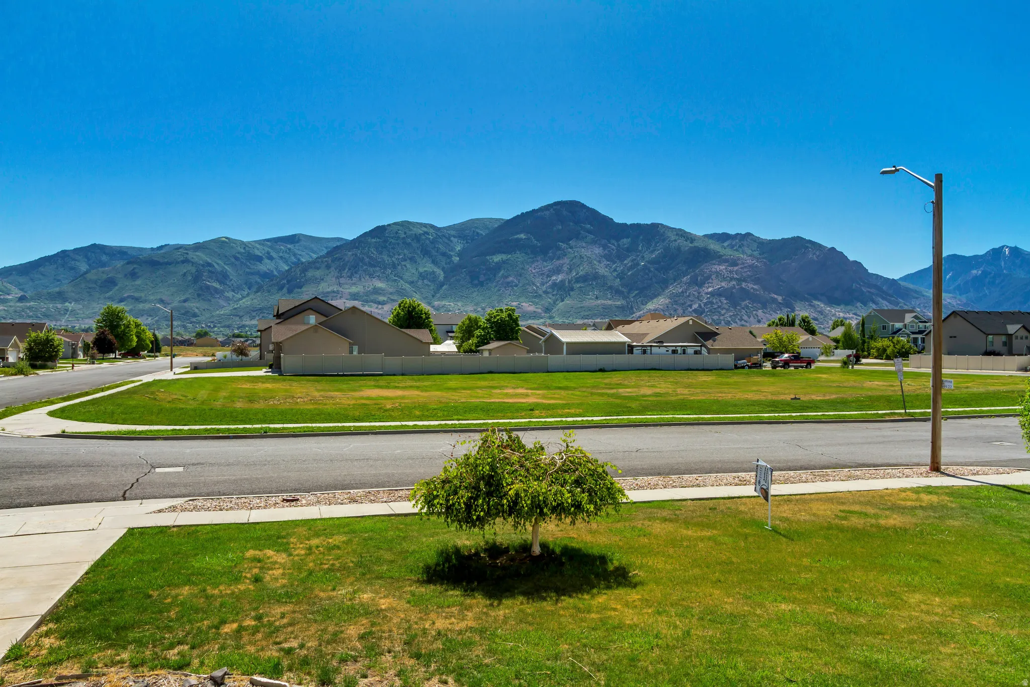 Expansive green space and paved roads framed by a distant mountain range