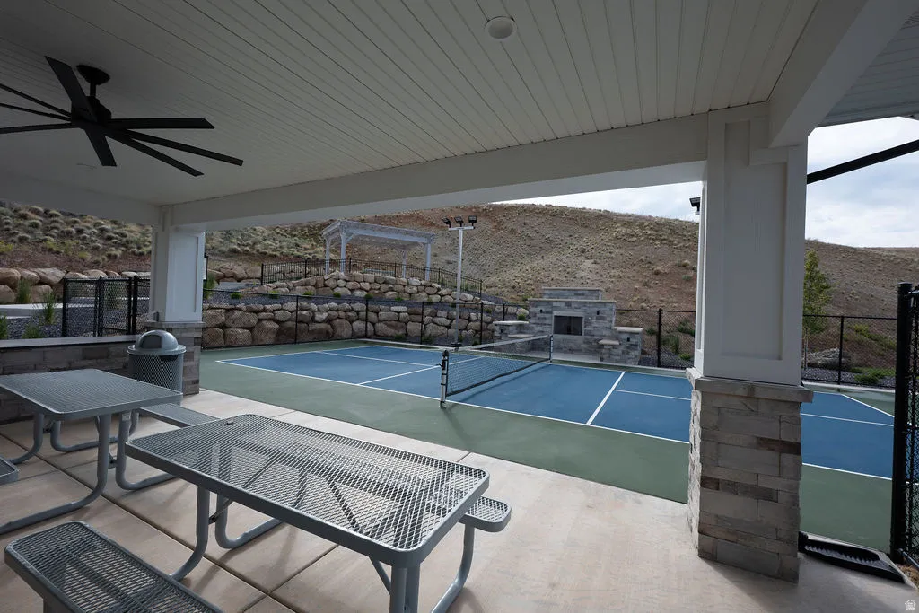 Covered patio area with a slatted ceiling and a large ceiling fan