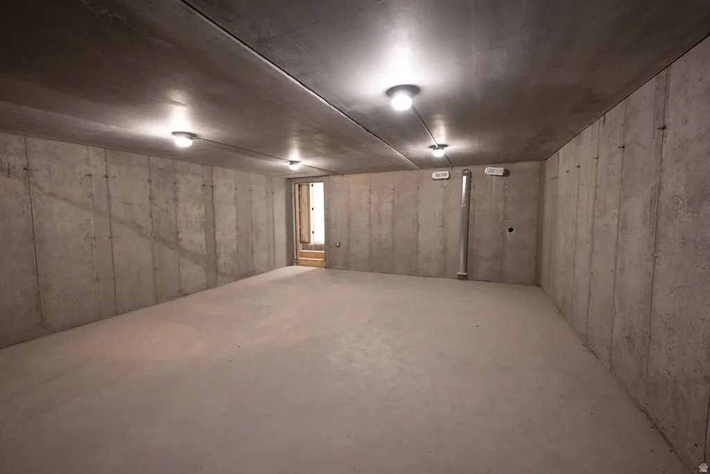 Spacious unfinished room with concrete walls and flooring