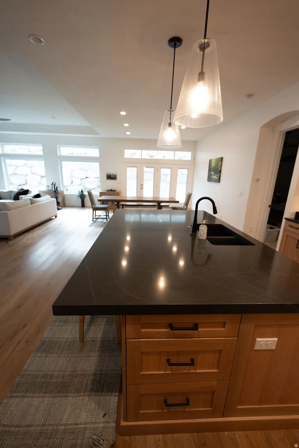 Kitchen island with a dark countertop and undermount sink