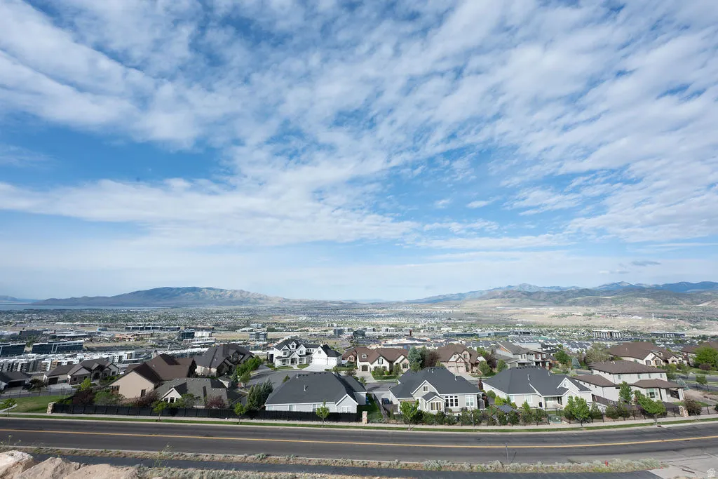 Expansive panorama showcasing a residential community with distant mountain ranges and a body of water