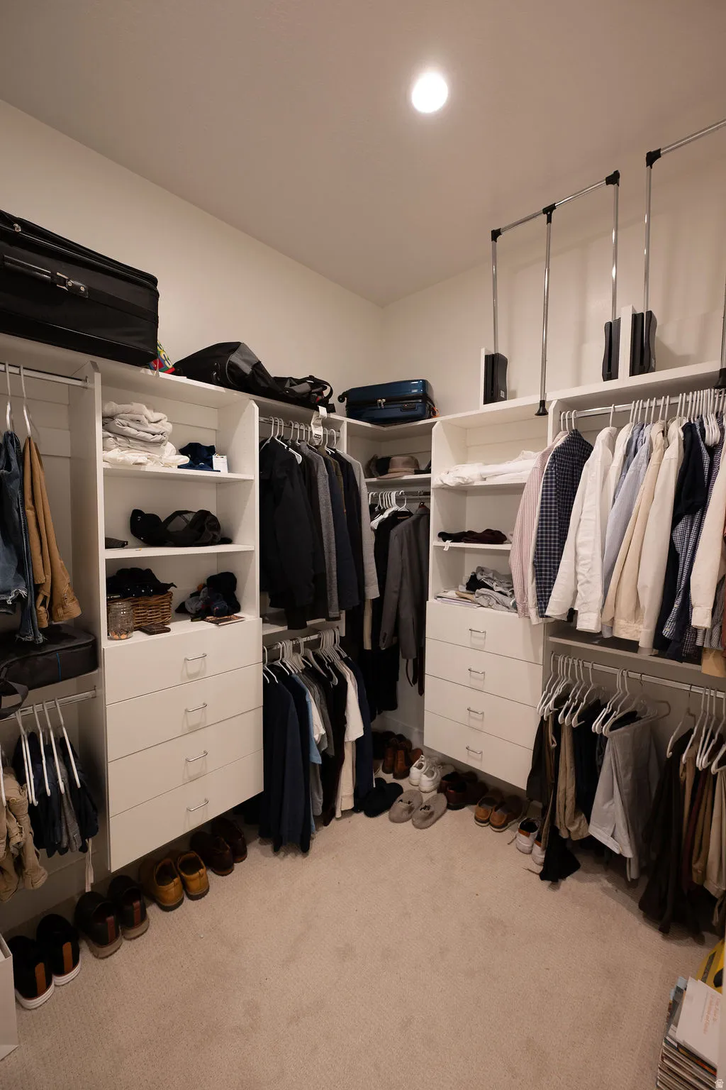 Custom-built closet system featuring multiple hanging rods, integrated shelving, and drawer storage